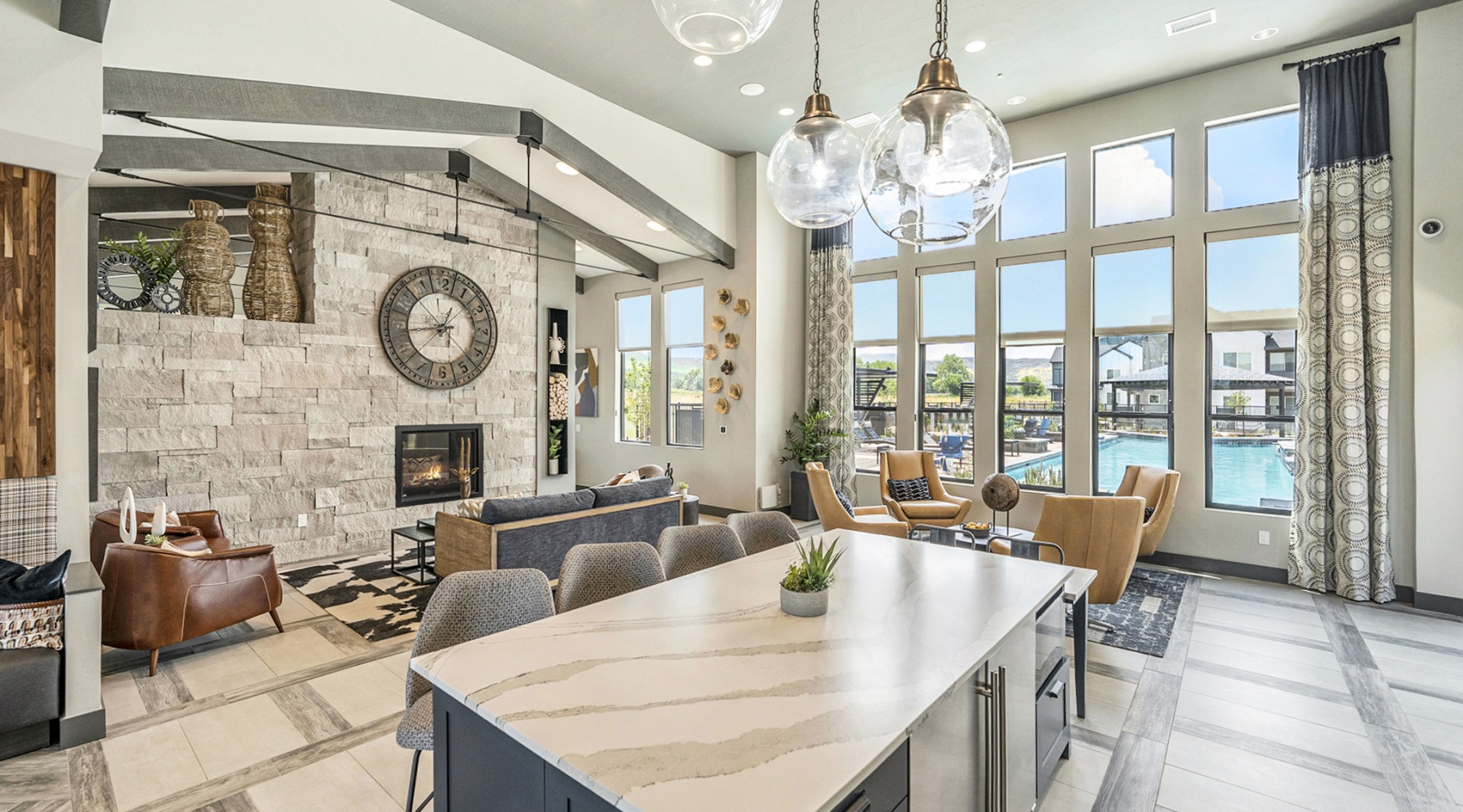Naturally at Home Clubroom with kitchen island, couches, and pool view